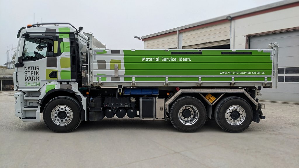 Beschriftung eines grünen Kipper-LKW