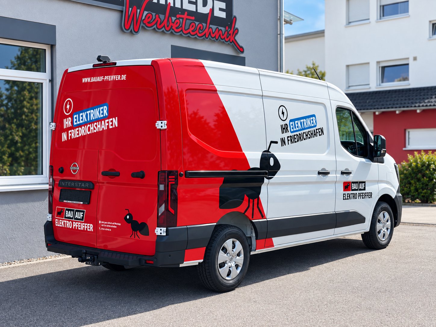 Rot-weiß beschrifteter Nissan Interstar von BAU AUF Elektro Pfeiffer vor der Folienschmiede