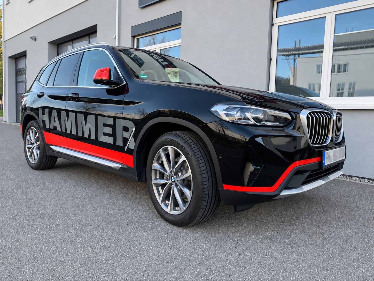 Schwarzer BMW X3 mit rot-grauer Fahrzeugbeschriftung für Hammer Heizungsbau