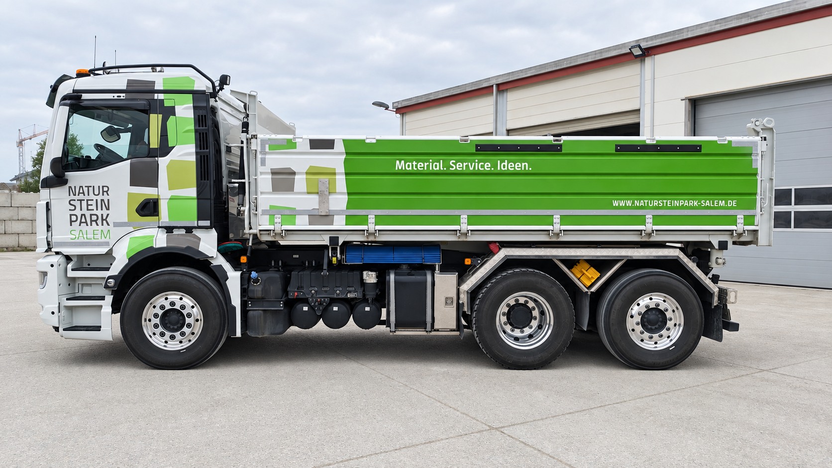 Beschriftung eines grünen Kipper-LKW